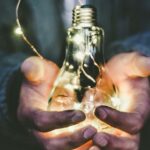 man holding incandescent bulb